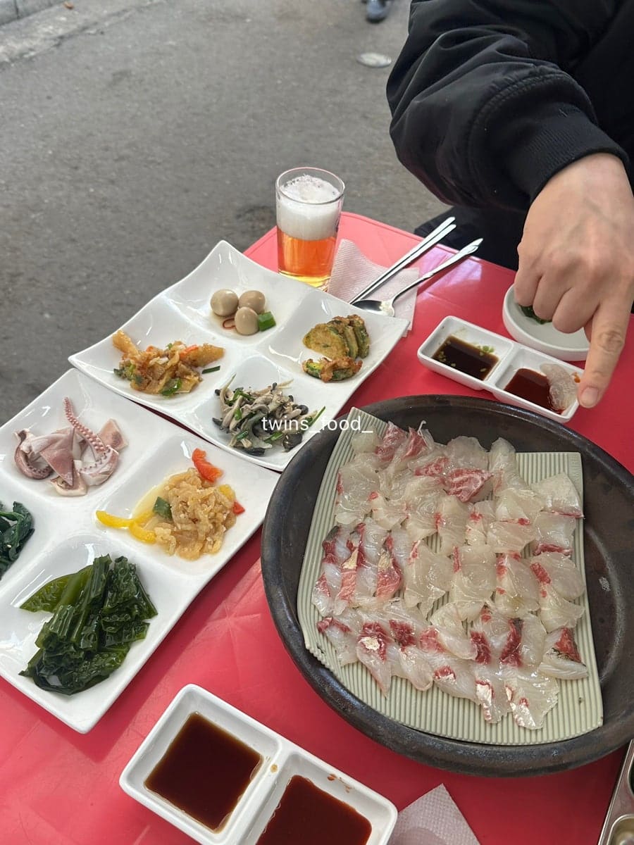 봄에 다시 찾은 yeajin1028은 18도까지 오른 날이라 야장에 앉았고, 마지막을 지리탕으로 마무리했다고 적었습니다. 붉은 상 위에 회와 여러 반찬이 한꺼번에 놓인 모습과,