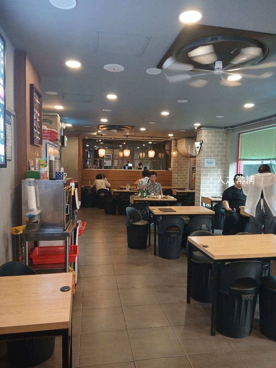 soic2364가 남긴 매장 안쪽 사진입니다. 나무 톤 테이블과 등받이 낮은 의자가 늘어선 홀에 손님이 드문드문 앉아 있고, 안쪽 조명 아래 목재 칸막이로 나뉜 자리도 보입니다.