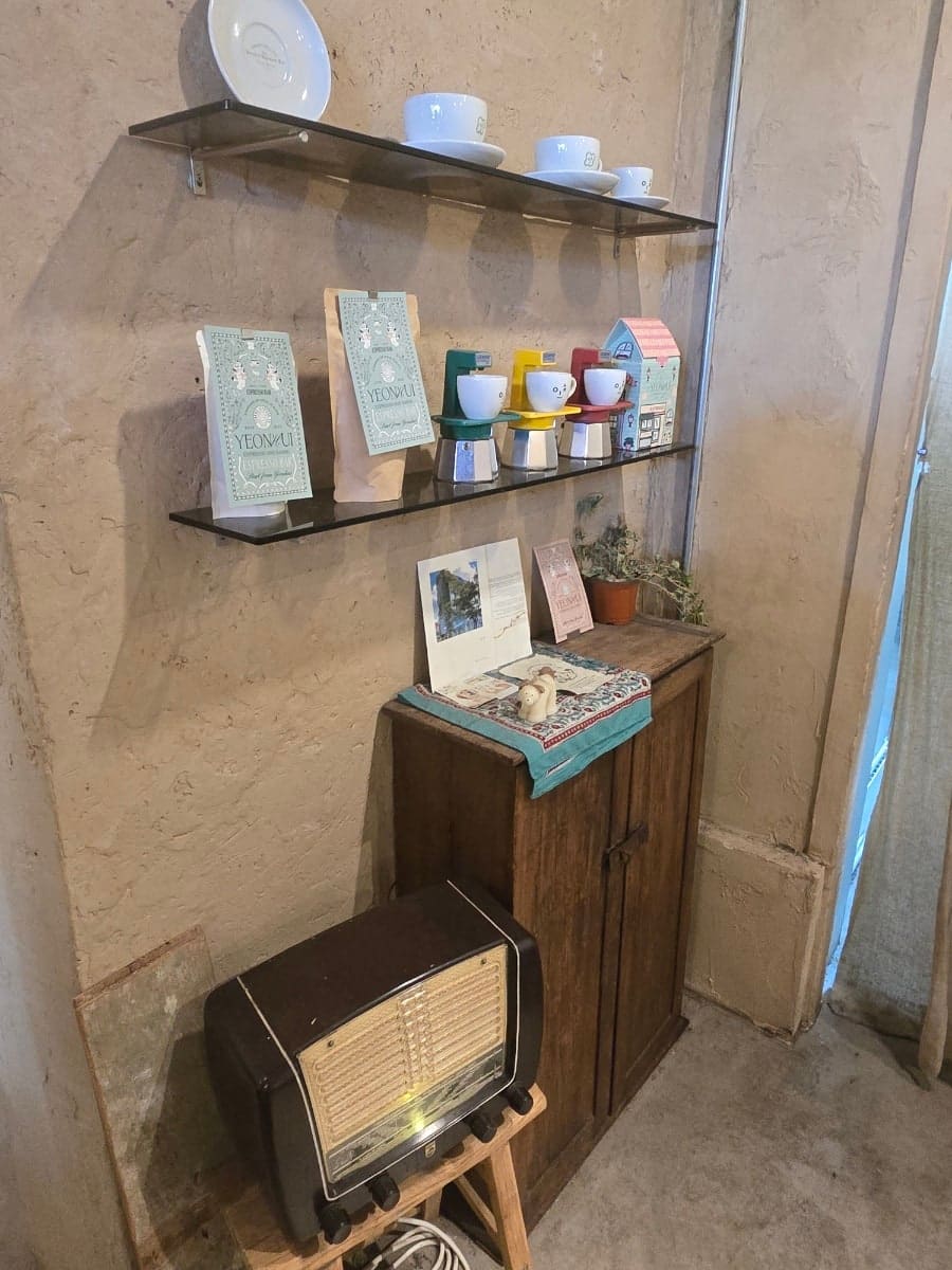 YEONHUI 라벨이 붙은 원두 봉지가 진열장에 놓여 있고, 옆엔 카페라떼·카페모카·비엔나커피가 한 트레이에 나란히 나옵니다.