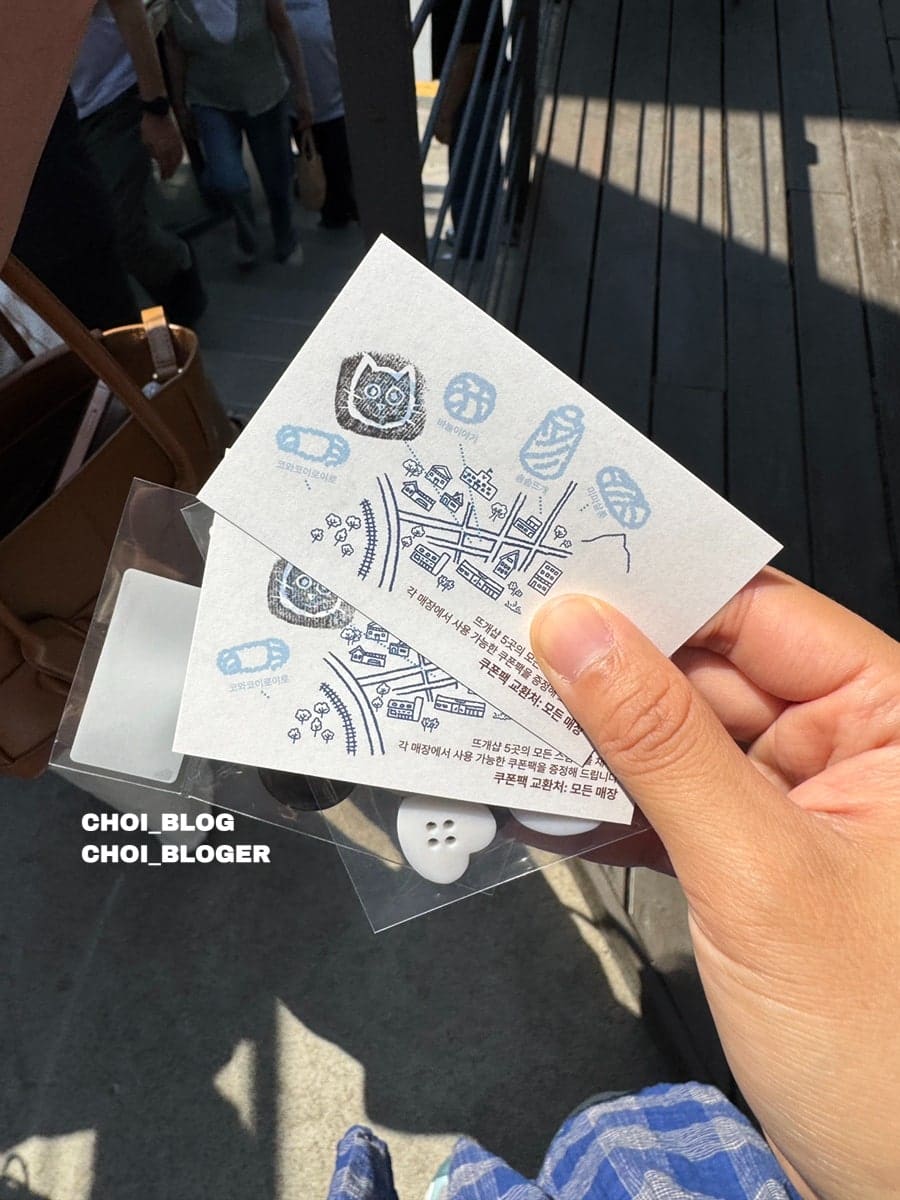 연희동 뜨개거리 행사 '똠똠마켓' 좌판입니다. 갖가지 단추와 실 뭉치가 QR 태그와 함께 나열돼 있고, 손님이 그중 마음에 드는 것을 고르고 있습니다.