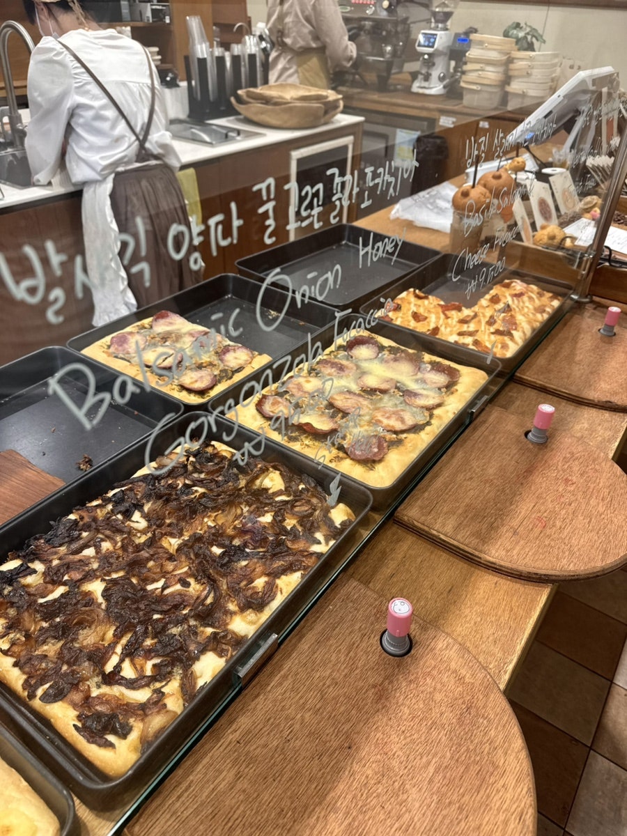 kimhong__이 찍은 포카치아와 디저트 진열대입니다. 발사믹 어니언 허니, 고르곤졸라 포카치아가 통째로 구워져 나오고,