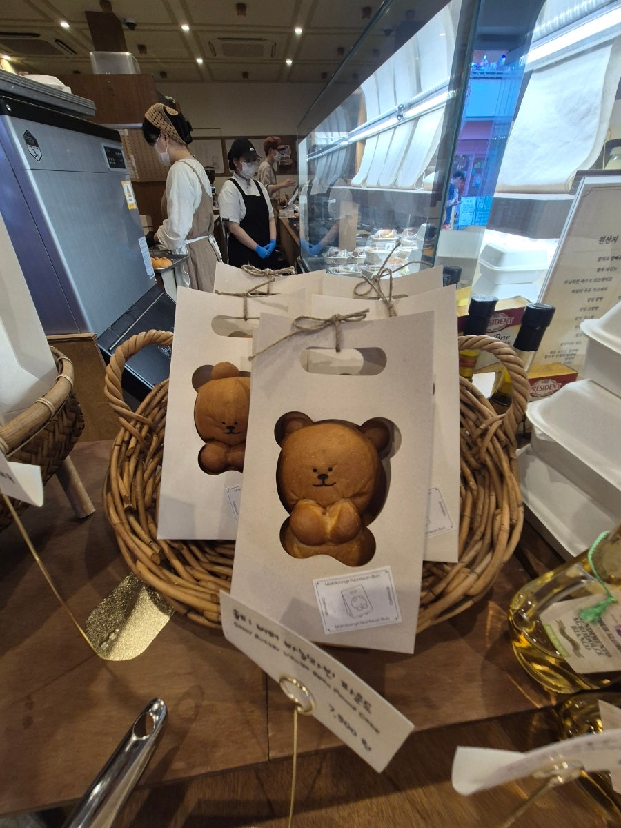 limmiae38이 담은 선물 포장 사진입니다. 곰 얼굴 모양 창이 뚫린 종이봉투 속 곰돌이빵과,