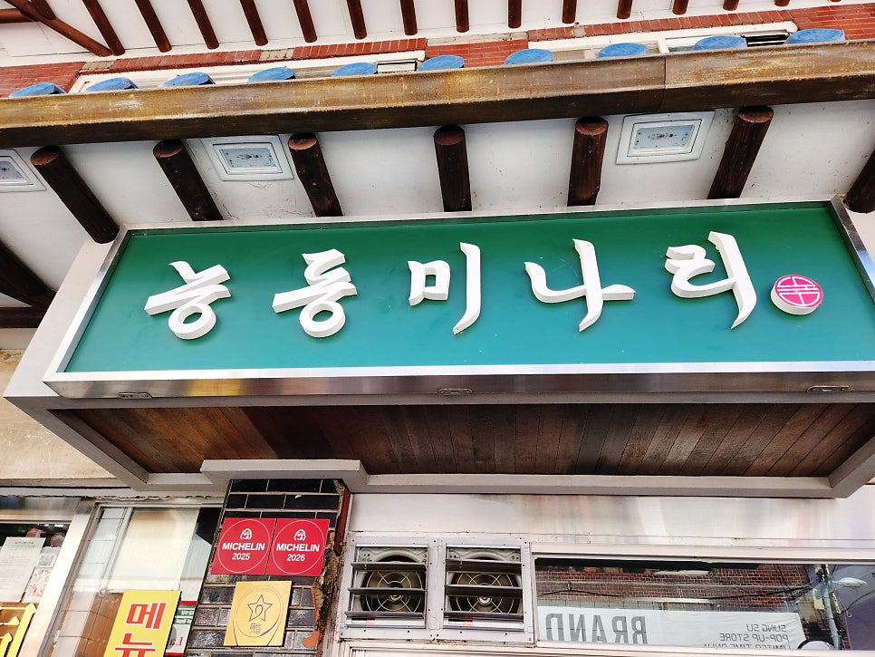 una_universe가 주말 데이트로 들렀을 때 찍은 외관입니다. 초록 간판 위로 기와지붕이 얹혀 있고, 그 옆에 2025·2026 미쉐린 스티커가 나란히 붙어 있습니다.