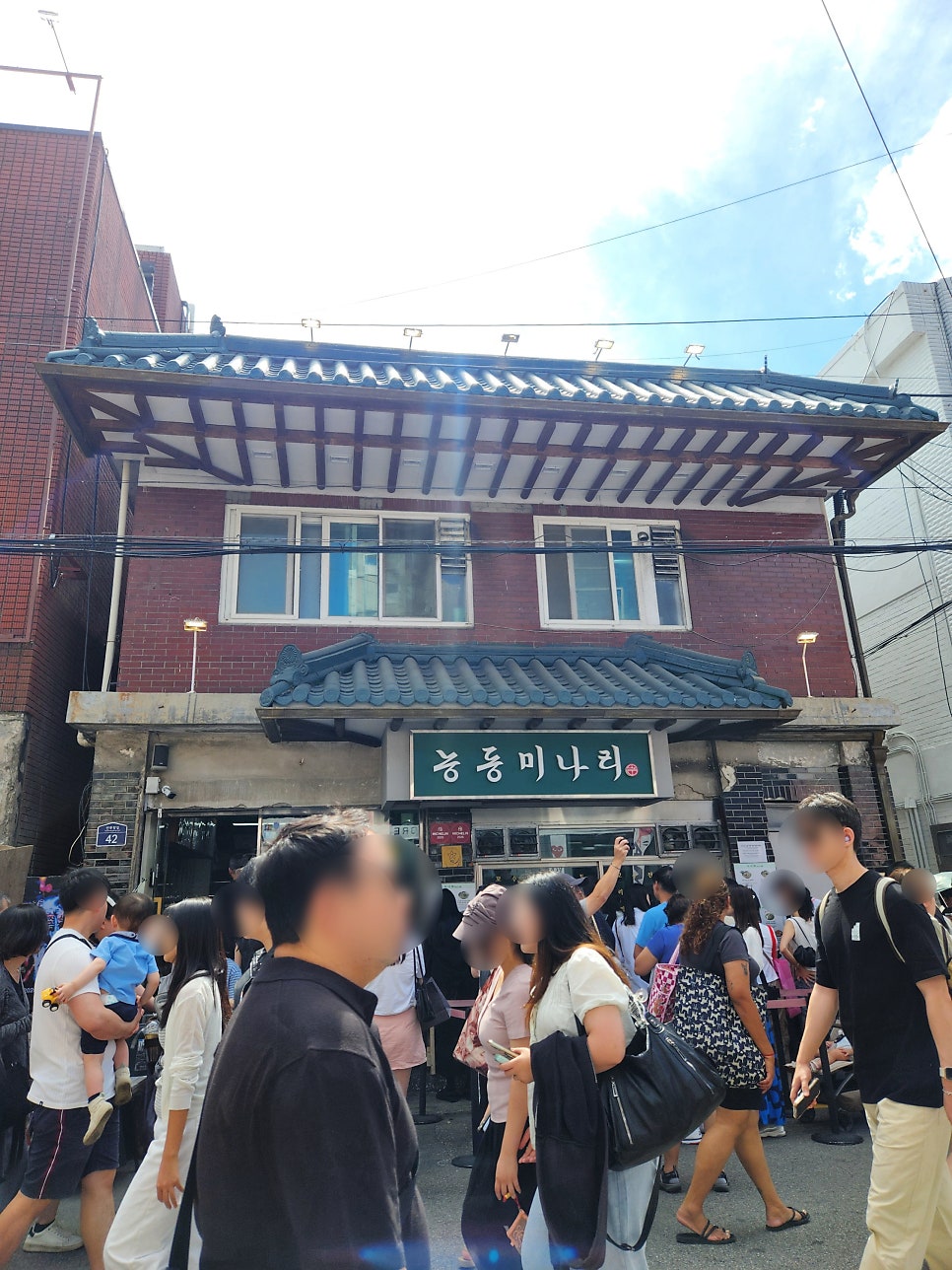 una_universe가 주말 데이트로 들렀을 때 찍은 외관입니다. 초록 간판 위로 기와지붕이 얹혀 있고, 그 옆에 2025·2026 미쉐린 스티커가 나란히 붙어 있습니다.