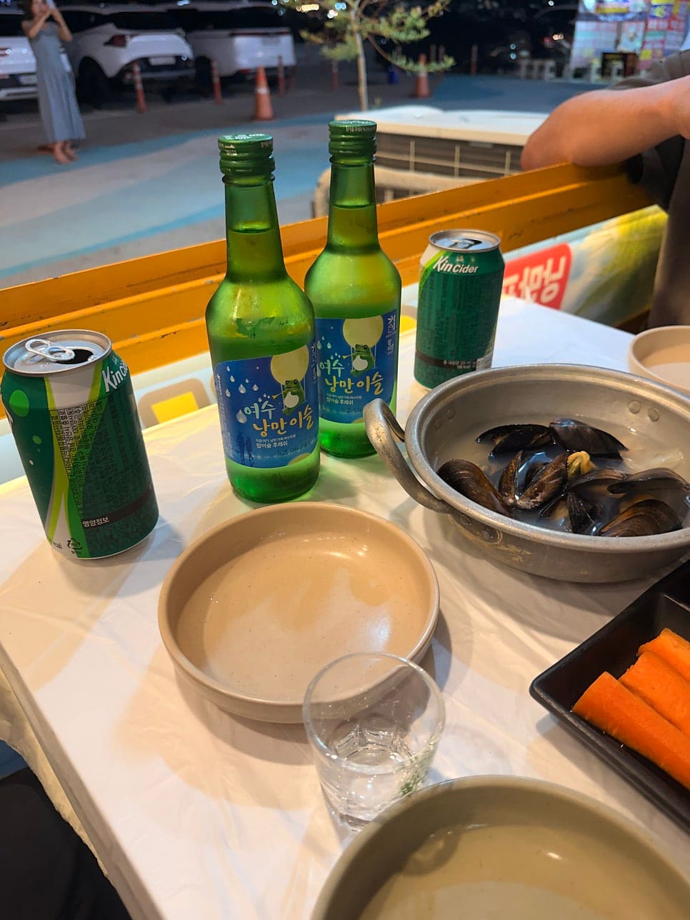 eli_joy_story가 담은 한 천막의 세트 메뉴판과 밤의 술상입니다. 정찰제 가격표 옆으로, 여수 낭만이슬 소주와 홍합탕이 놓인 테이블이 이어집니다.