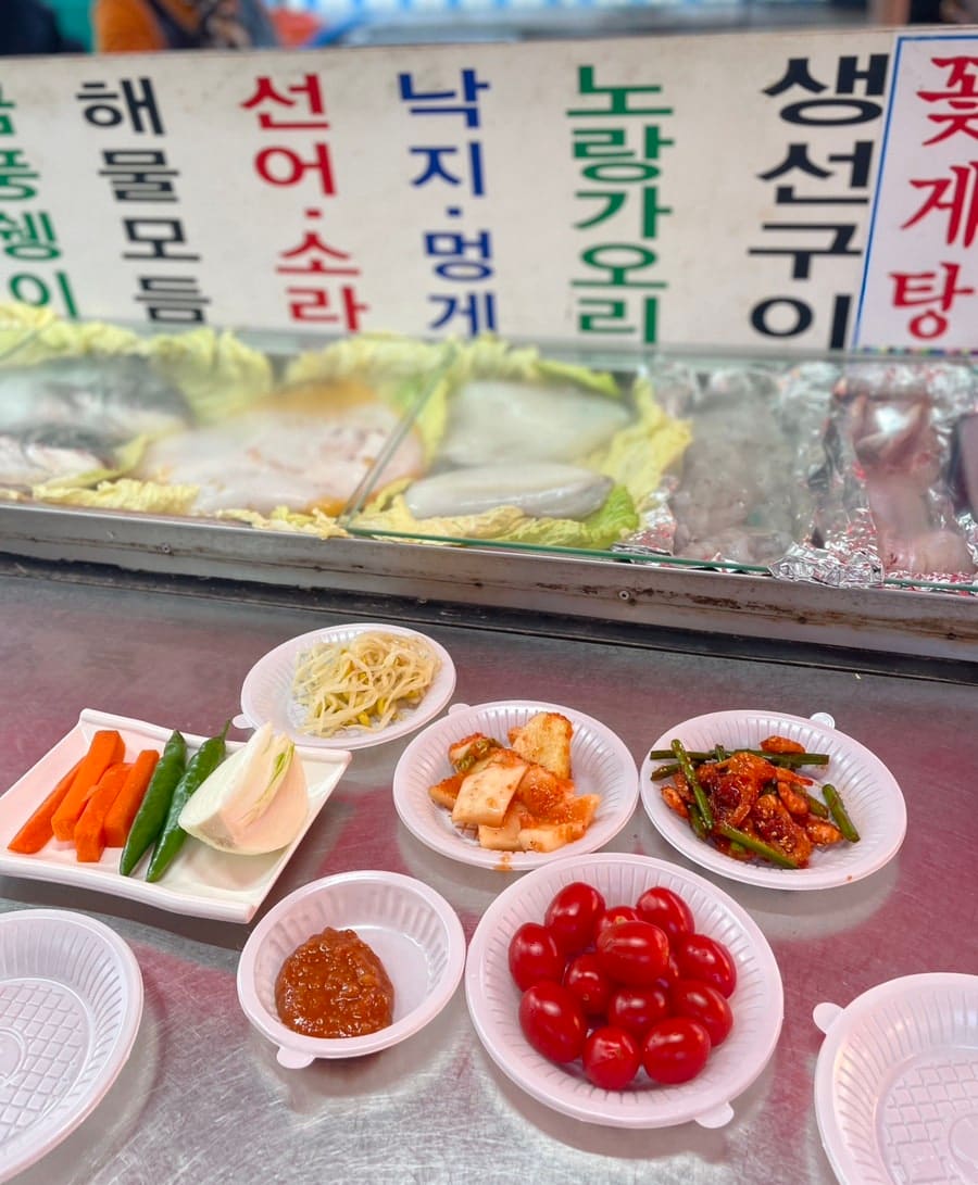 seulkyomi가 담은 골목 초입입니다. 파란 줄무늬 천막에 빨간 '23번' 표지판이 걸려 있어 멀리서도 이 집을 알아볼 수 있습니다. 다른 컷은 바로 옆 수족관으로,