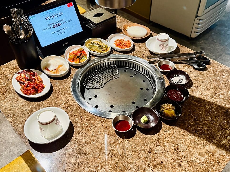 dustella는 물이 보리차로 나오는 순간부터 첫인상이 합격이었다고 적었습니다. 하늘이 걸린 간판 아래 벽돌 건물의 외관과,